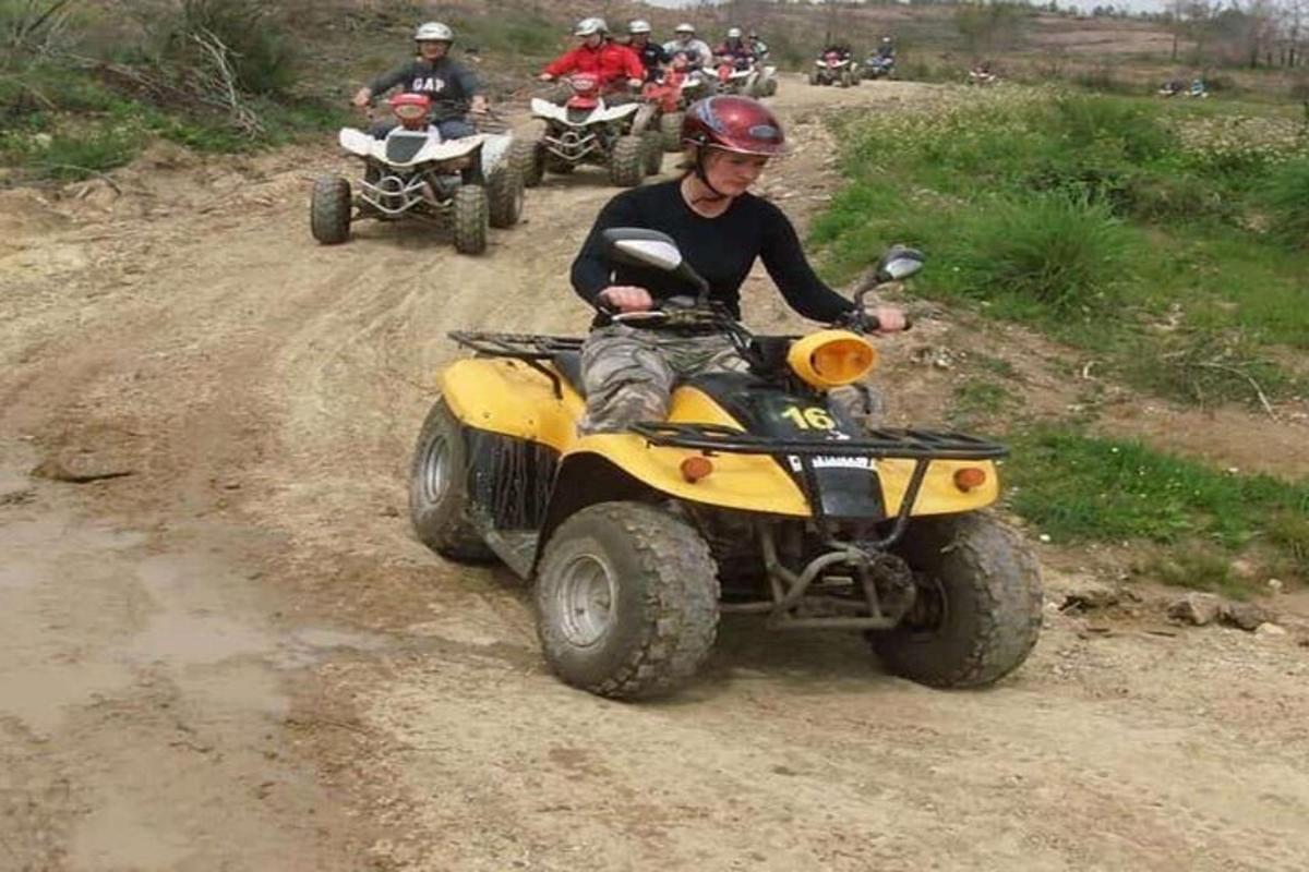 un uomo che guida un quad su una strada sterrata
