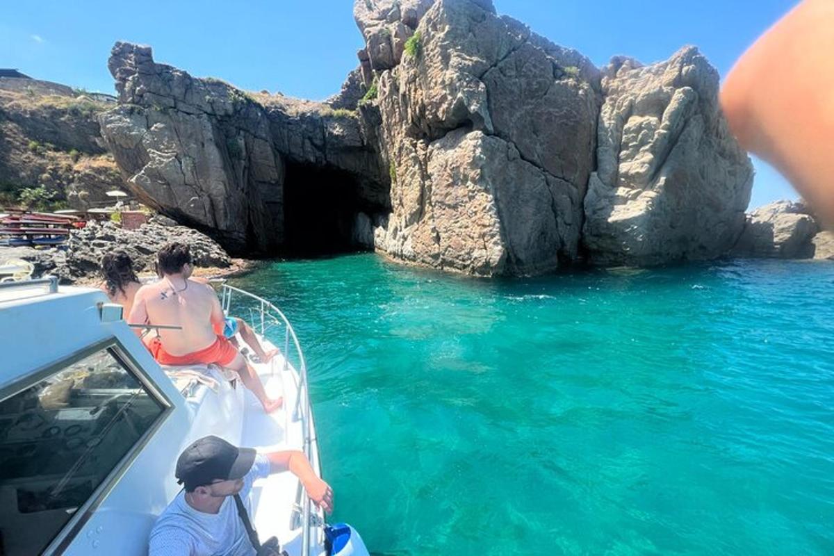 a group of people on a boat in front of a cave