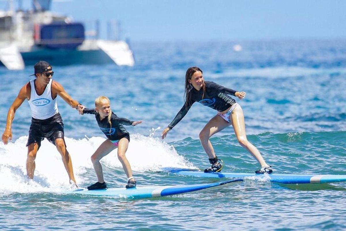 tres persones cavalcant una onada sobre taules de surf a l'oceà