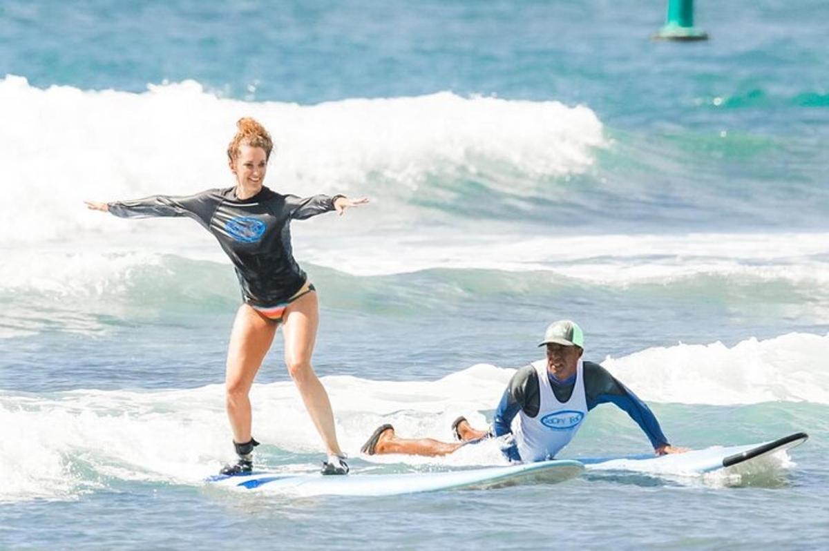 un home i una dona sobre taules de surf a l'oceà