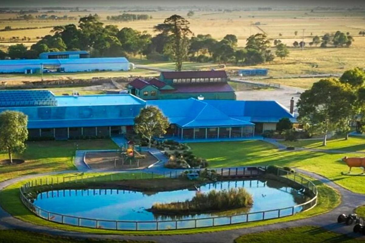 an overhead view of a large blue building with a pond