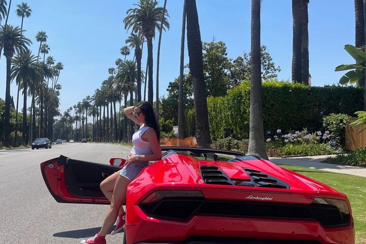 жінка сидить на капоті червоного Lamborghini