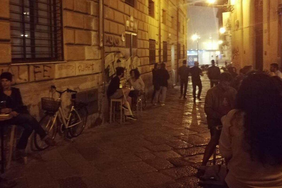 Un grupo de personas sentadas en una calle por la noche.