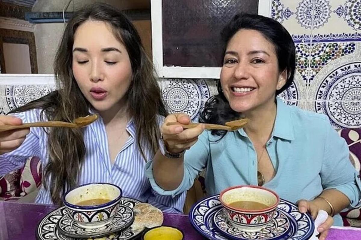 due donne sono sedute a un tavolo e mangiano la zuppa