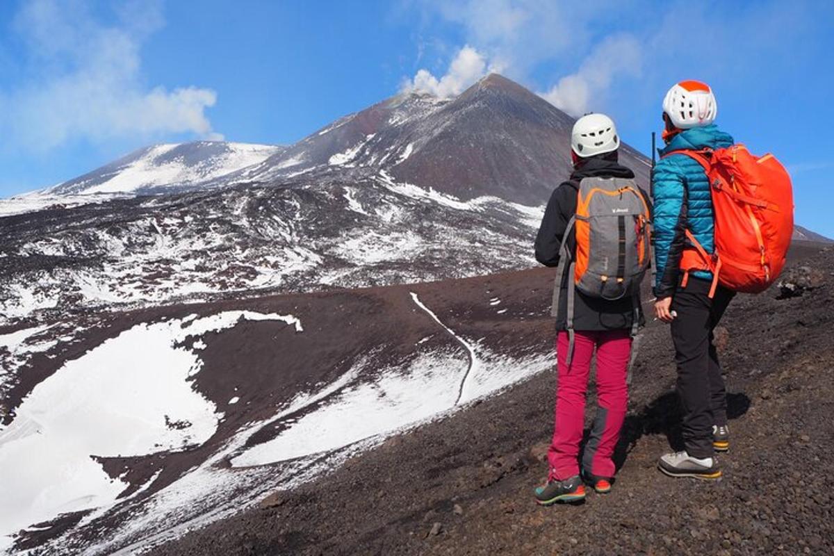 duas pessoas em pé no topo de uma montanha coberta de neve