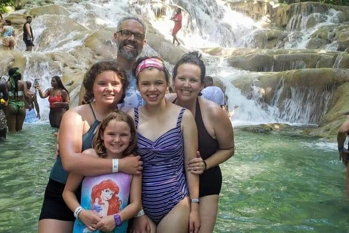 un gruppo di persone in piedi davanti a una cascata