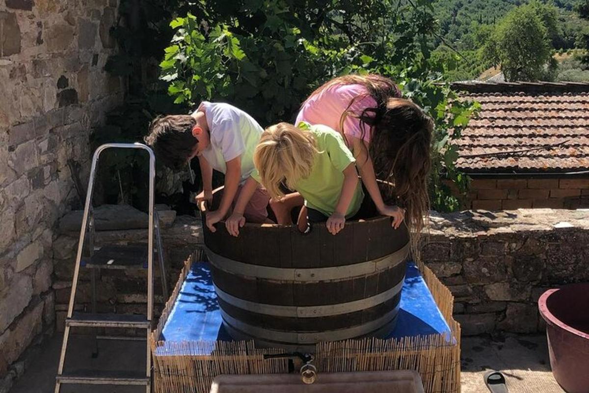 tre bambini che giocano in un barile d'acqua