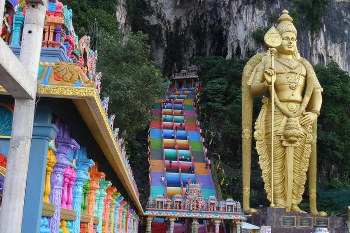 una grande statua d'oro in piedi accanto a un edificio colorato