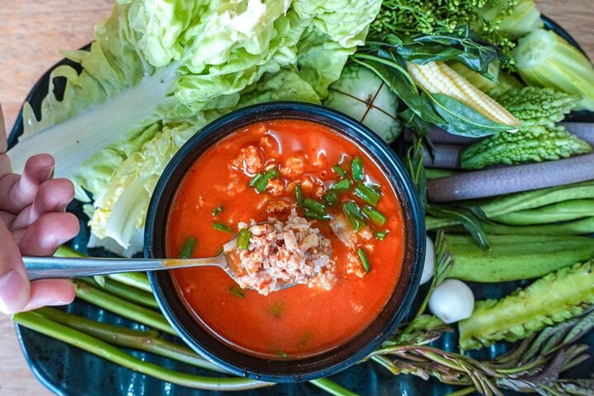 a bowl of tomato soup on a plate with vegetables