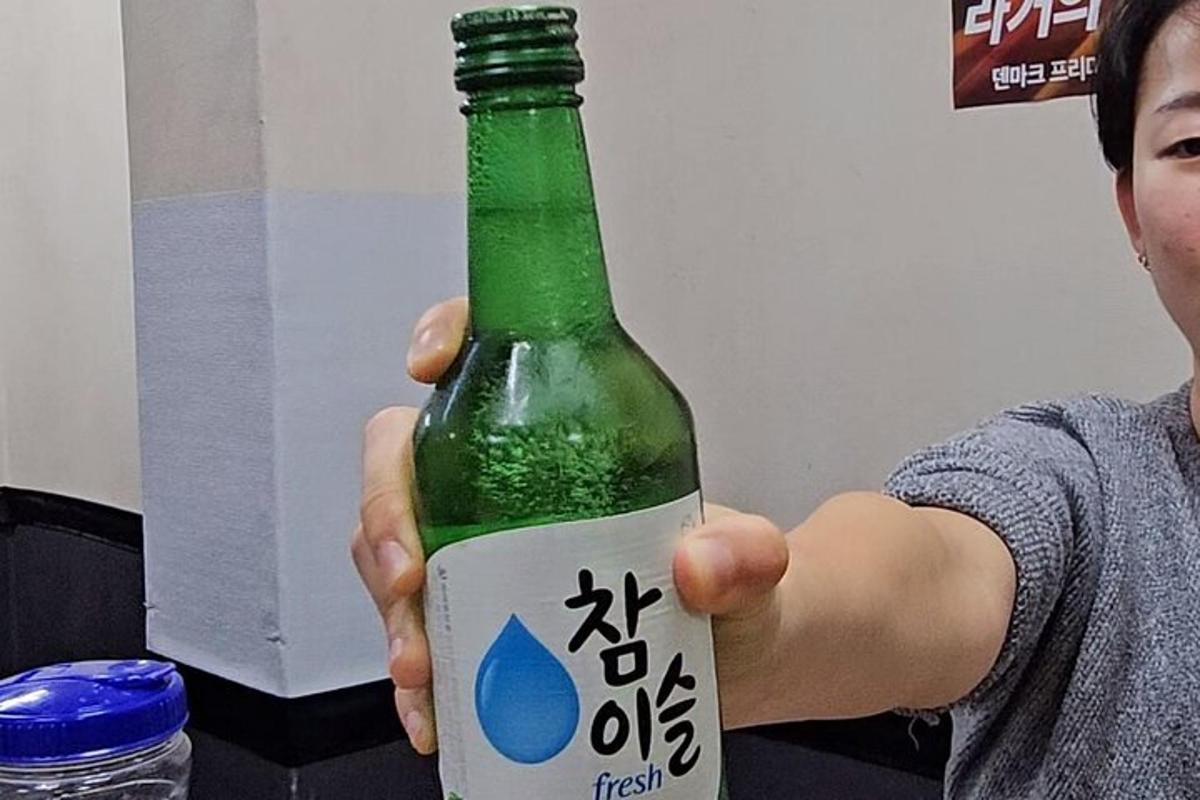 un uomo tiene in mano una bottiglia verde con una scritta sopra