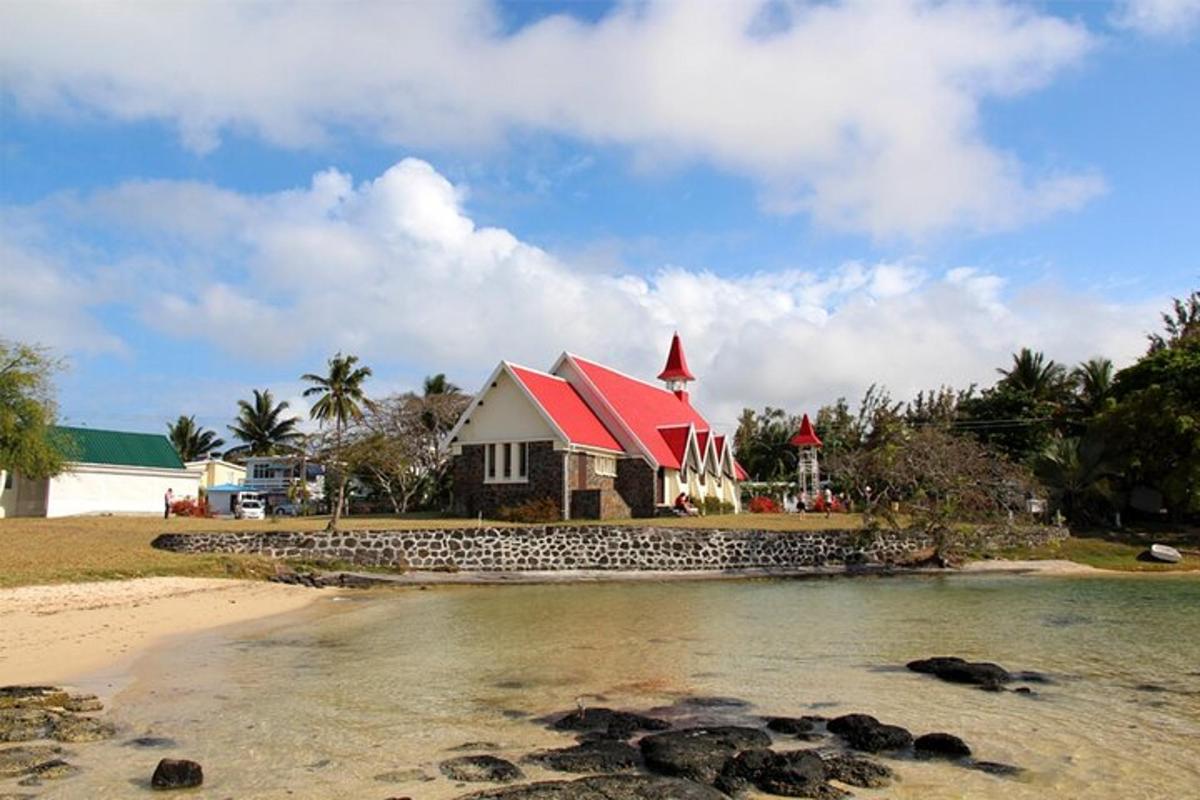 a house with a red roof next to a beach