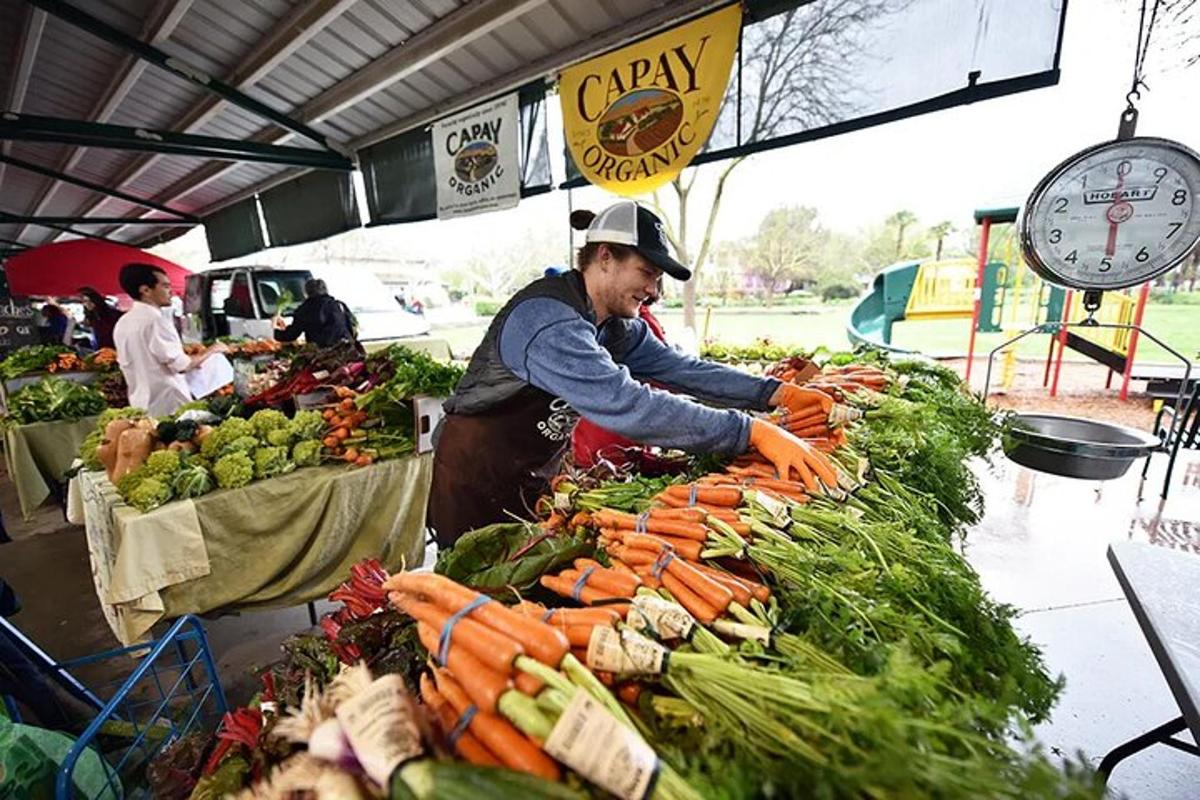 a man selling vegetables at a farmers market