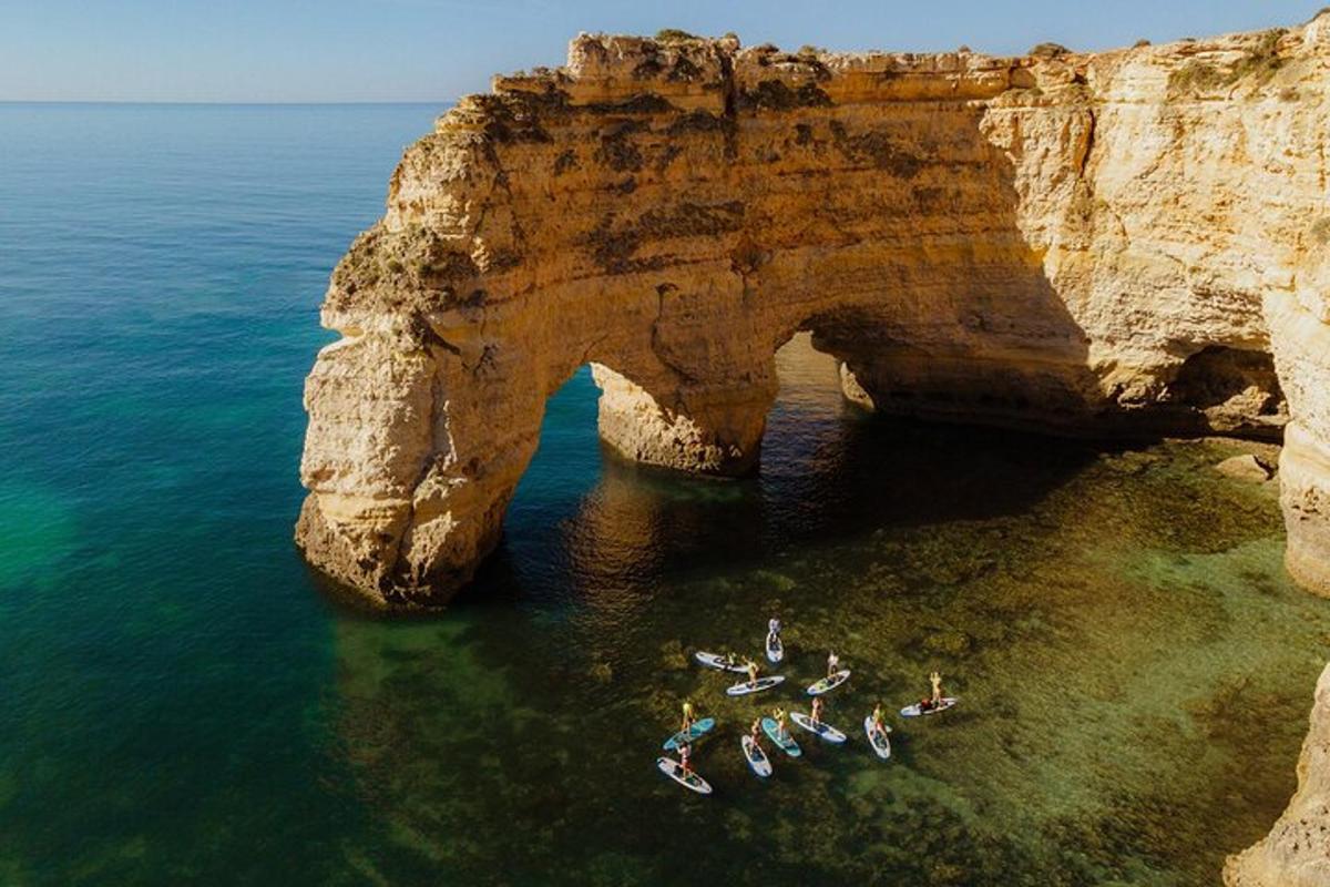 un gruppo di persone in acqua vicino a un arco nell'oceano
