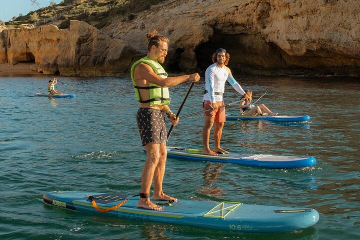 due uomini sono in piedi su tavole da paddle in acqua