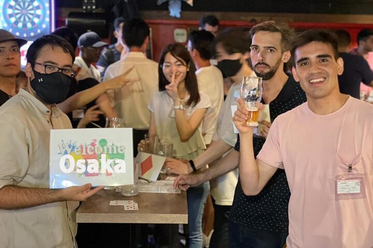 skupina ljudi, ki stojijo okoli mize s pijačo
