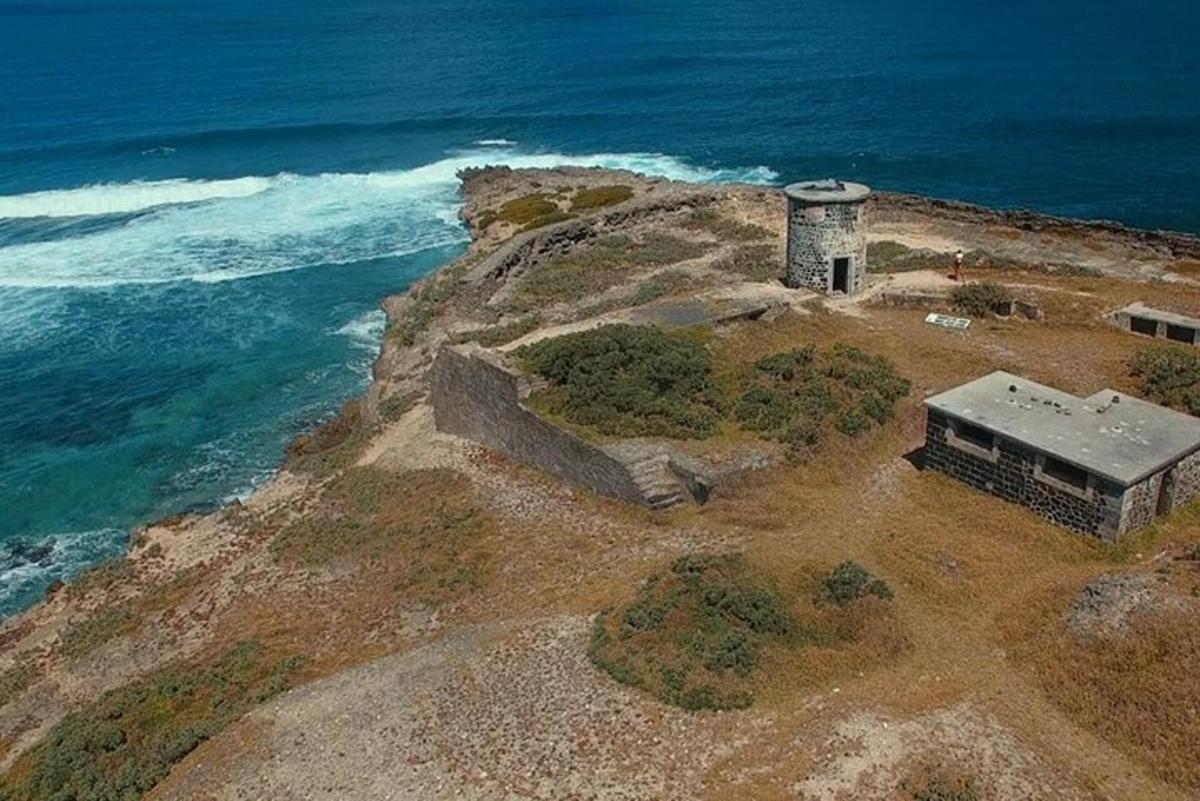 un piccolo edificio sul bordo di una scogliera vicino all'oceano