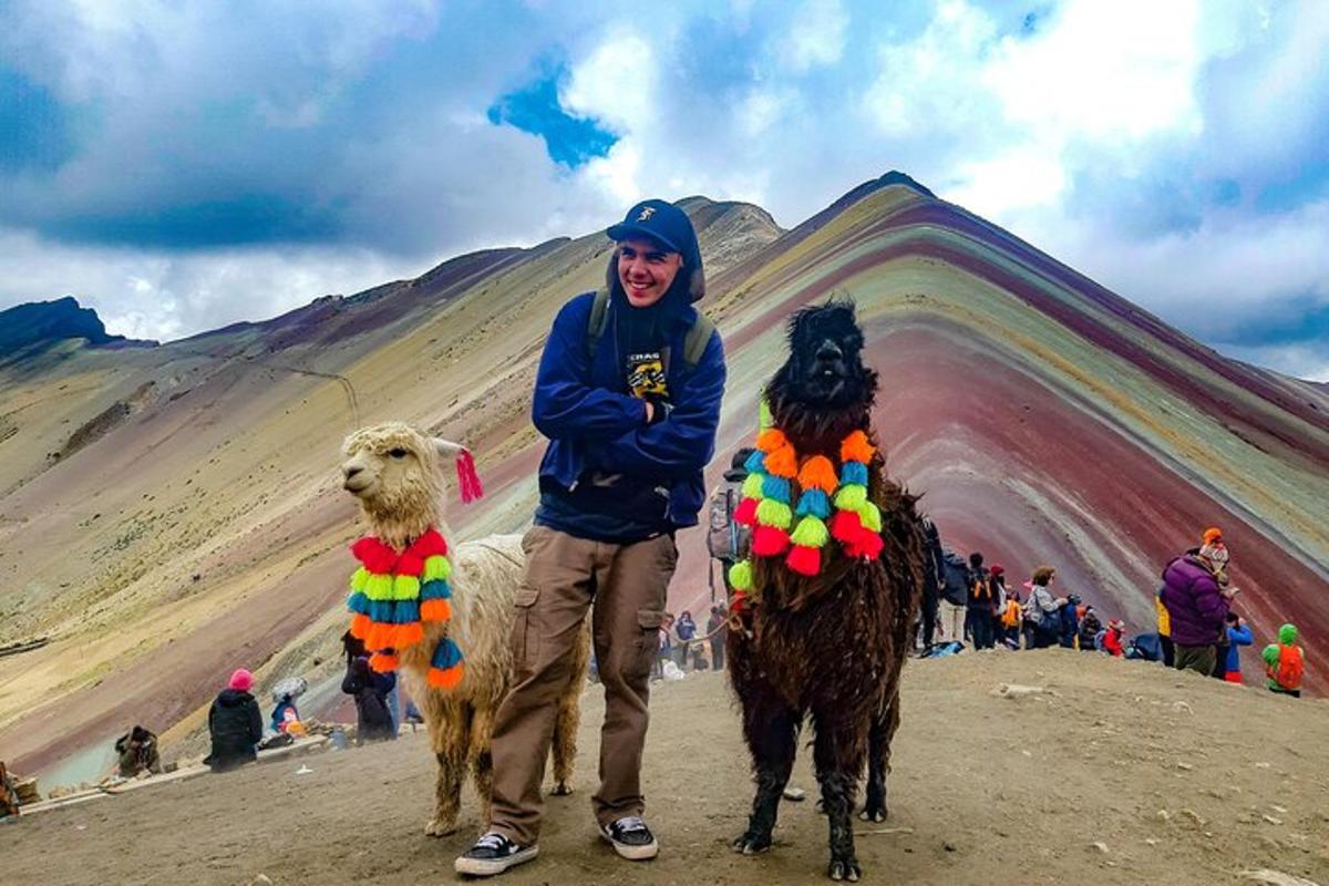 Un hombre está de pie junto a dos ovejas.