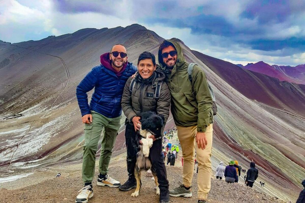 Un grupo de tres personas y un perro en una montaña
