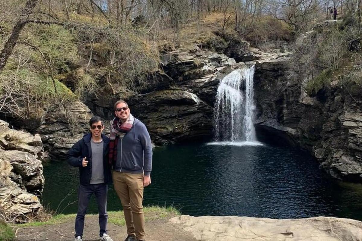 un uomo e una donna in piedi davanti a una cascata