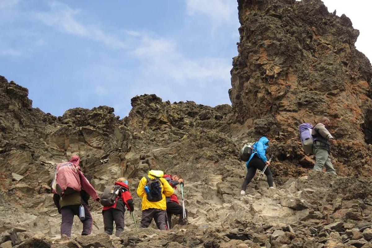 un gruppo di persone che cammina su una montagna rocciosa