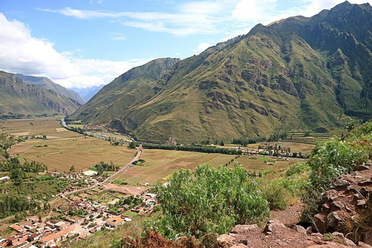 una persona parada en la cima de una colina con vista a un valle