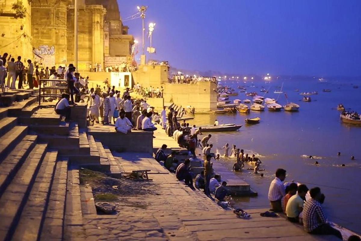 a group of people sitting on steps next to a body of water