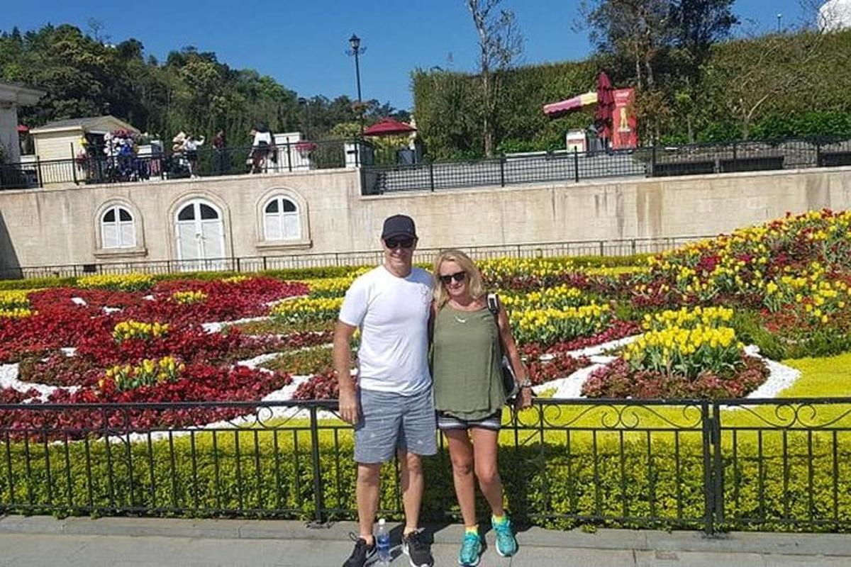 un home i una dona drets davant d'un jardí de flors