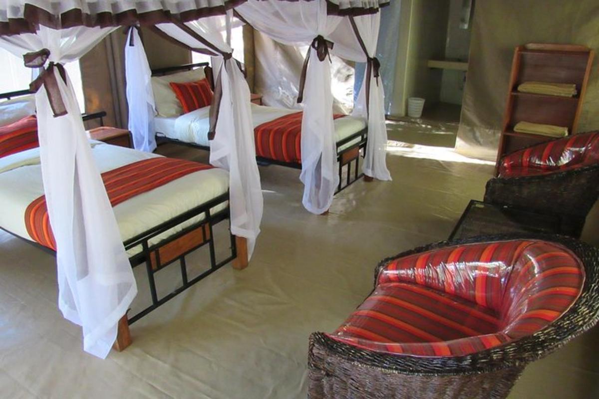 um quarto com duas camas, uma cadeira e um sofá