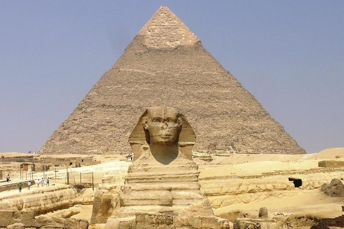 a large statue in front of a pyramid