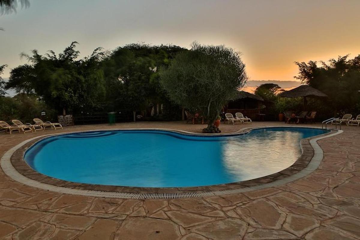 una grande piscina con un tramonto sullo sfondo
