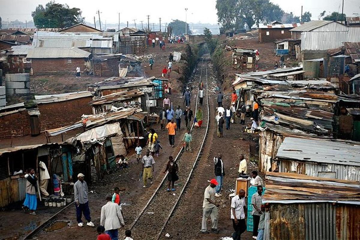 eine Gruppe von Menschen, die durch ein Dorf mit Bahngleisen laufen