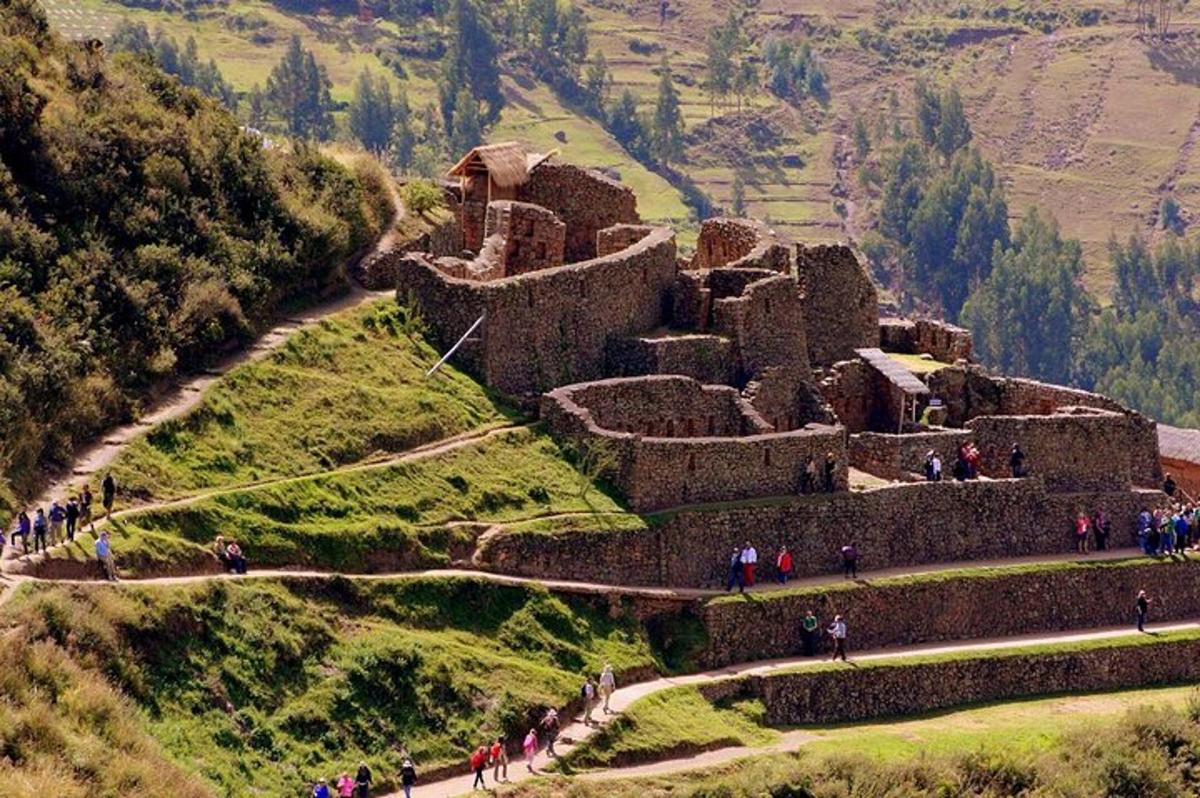 um grupo de pessoas caminhando ao redor de um castelo em uma colina