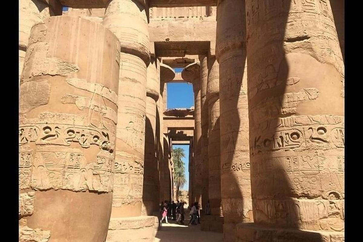 ένα αρχαίο κτίριο με κίονες και ανθρώπους που περπατούν μέσα από αυτό