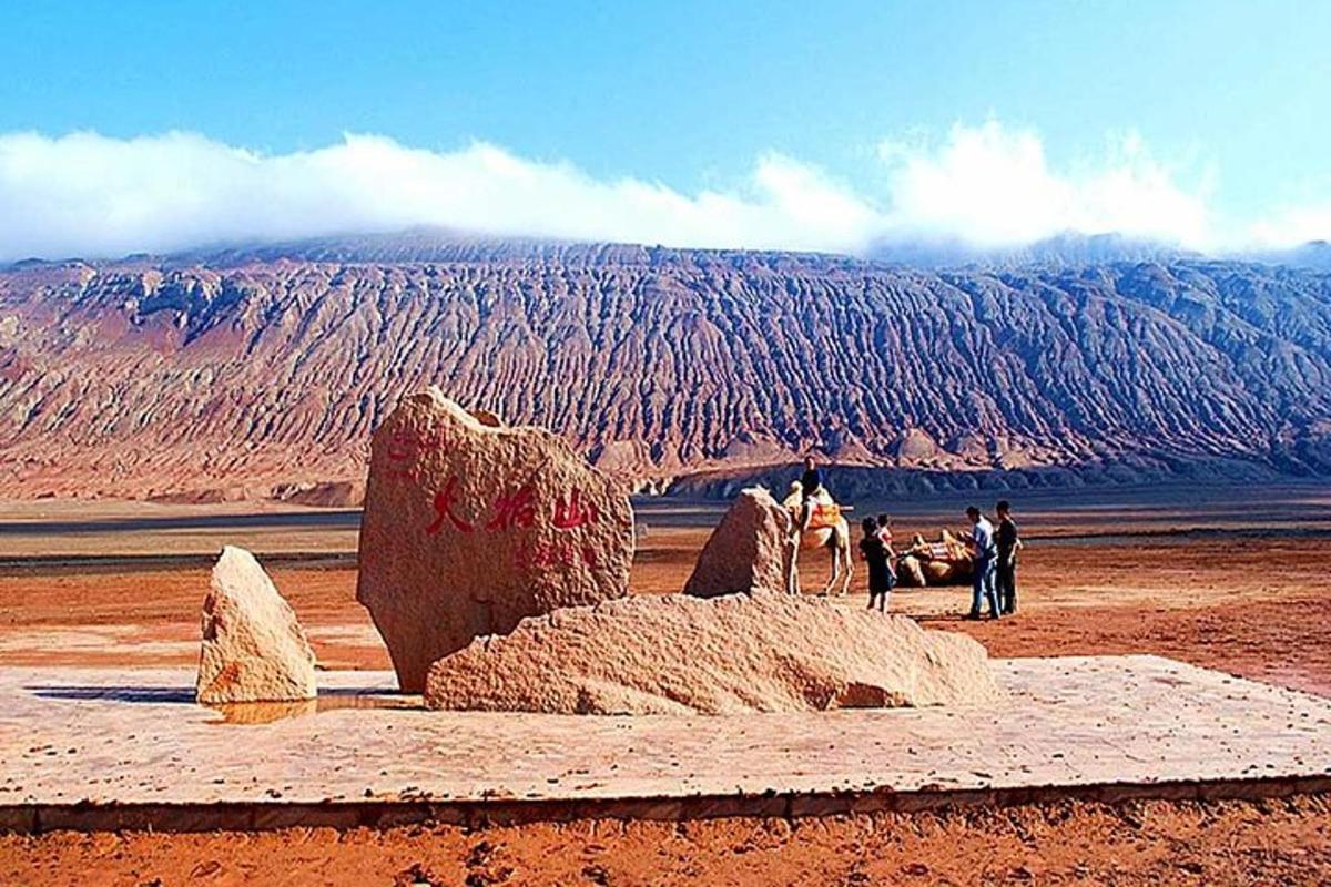 uma escultura no deserto com uma montanha ao fundo