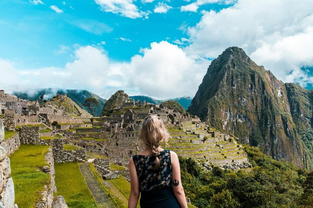 una donna in piedi sulle rovine di Machu Picchu in montagna
