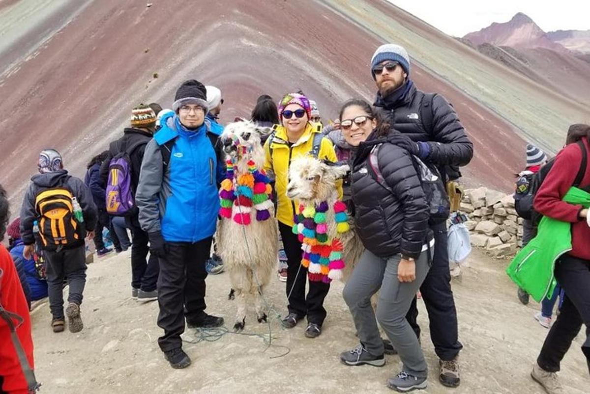 skupina lidí stojících na hoře s lamou