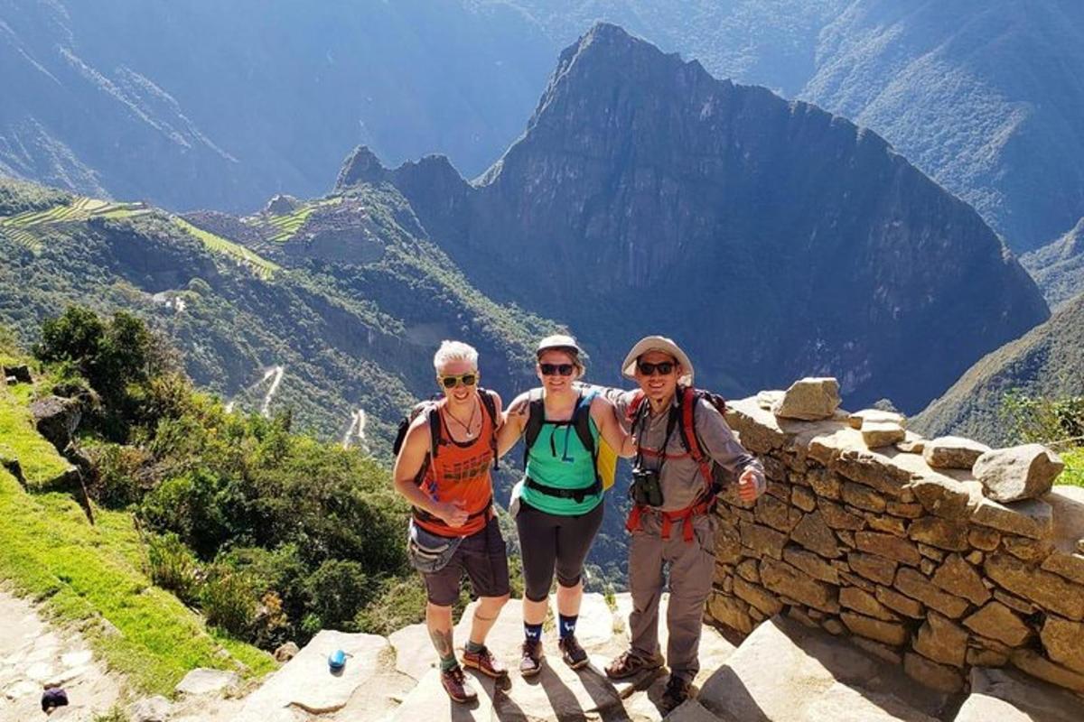 drie mensen staan op de rand van een berg
