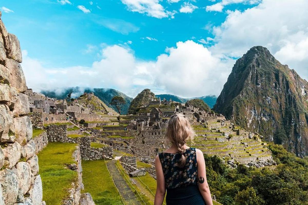 naine seisab Machu Picchu varemete tipus