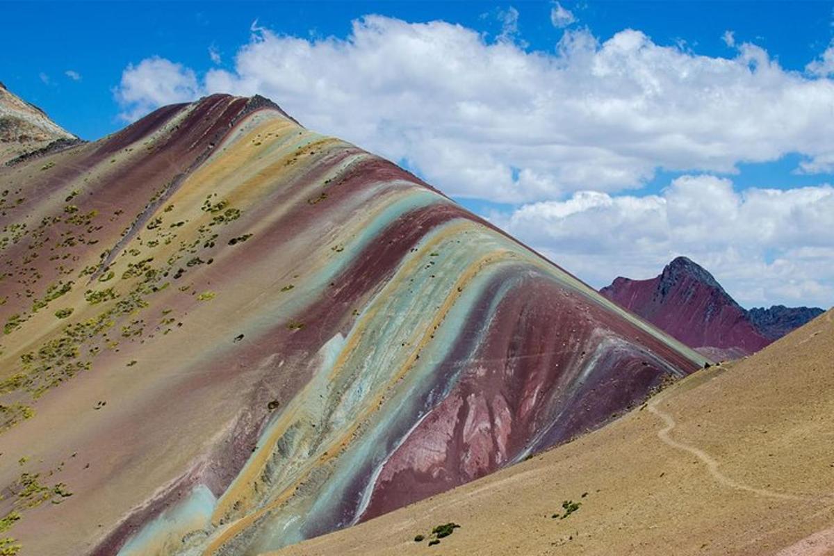 een berg met een regenboog aan de zijkant