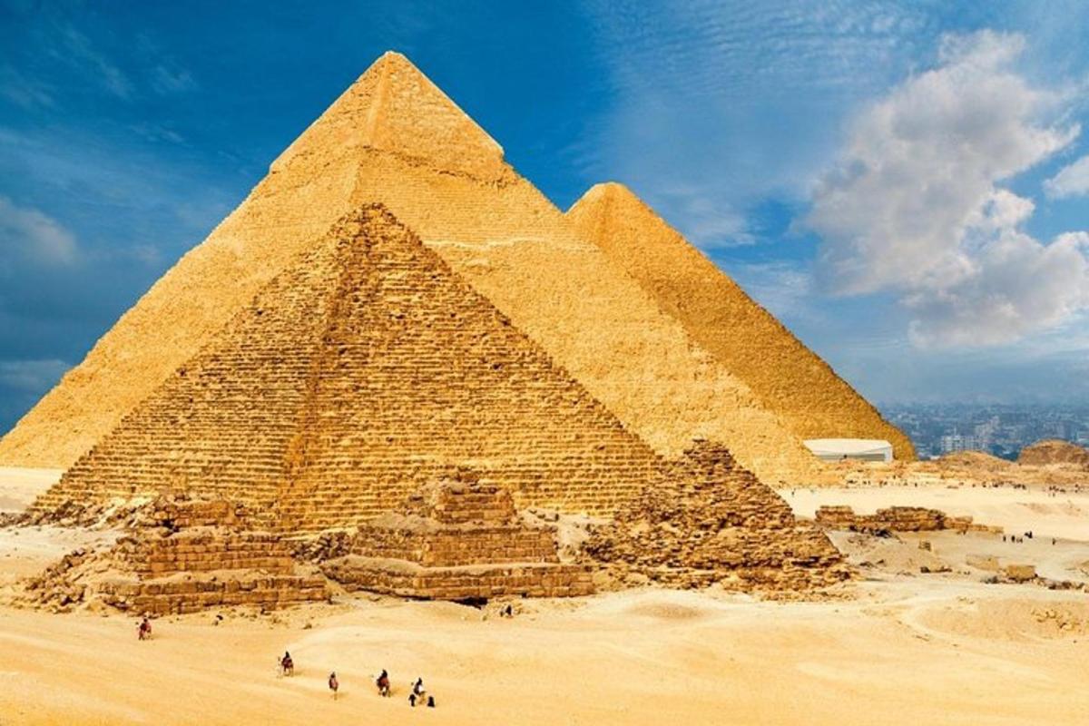 skupina lidí stojící před pyramidou