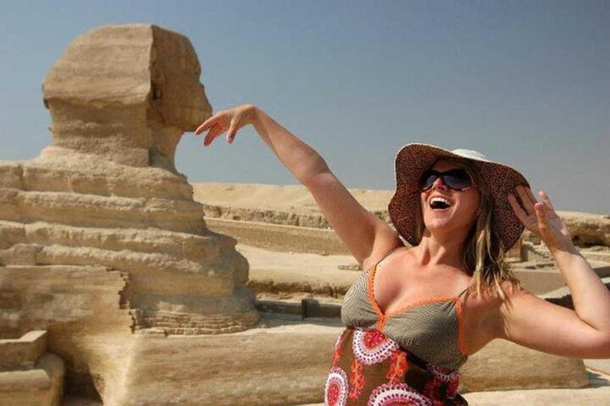 eine Frau steht vor einer Pyramide