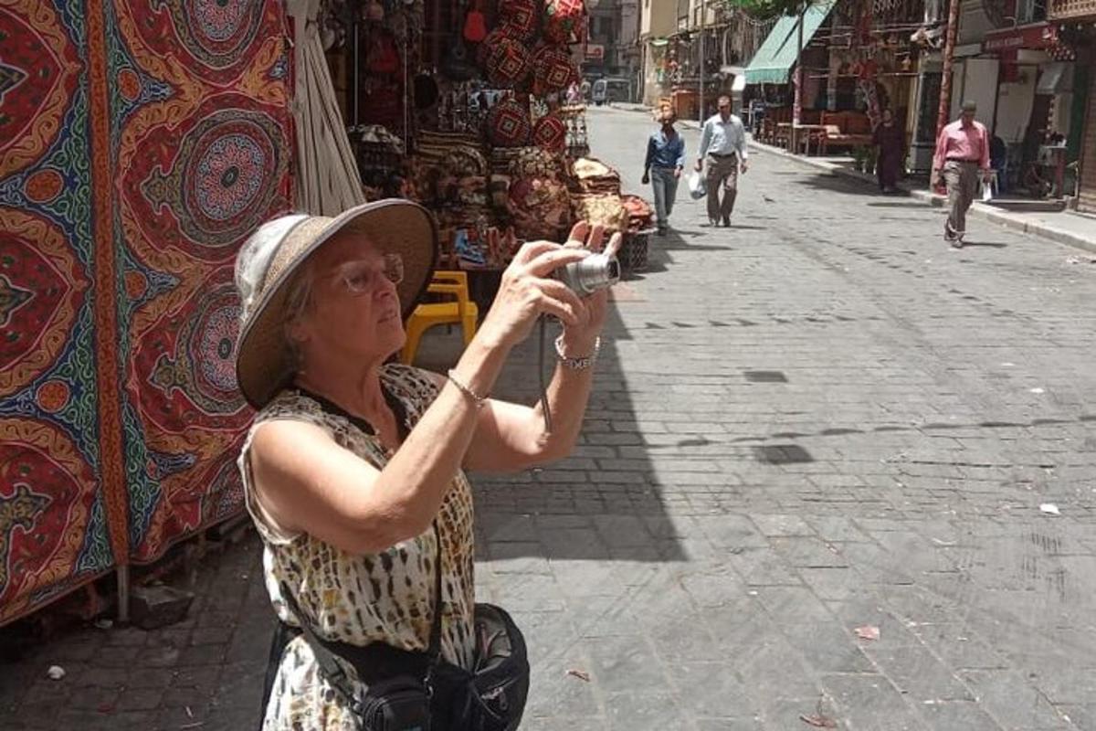 a woman taking a picture of a street with a camera