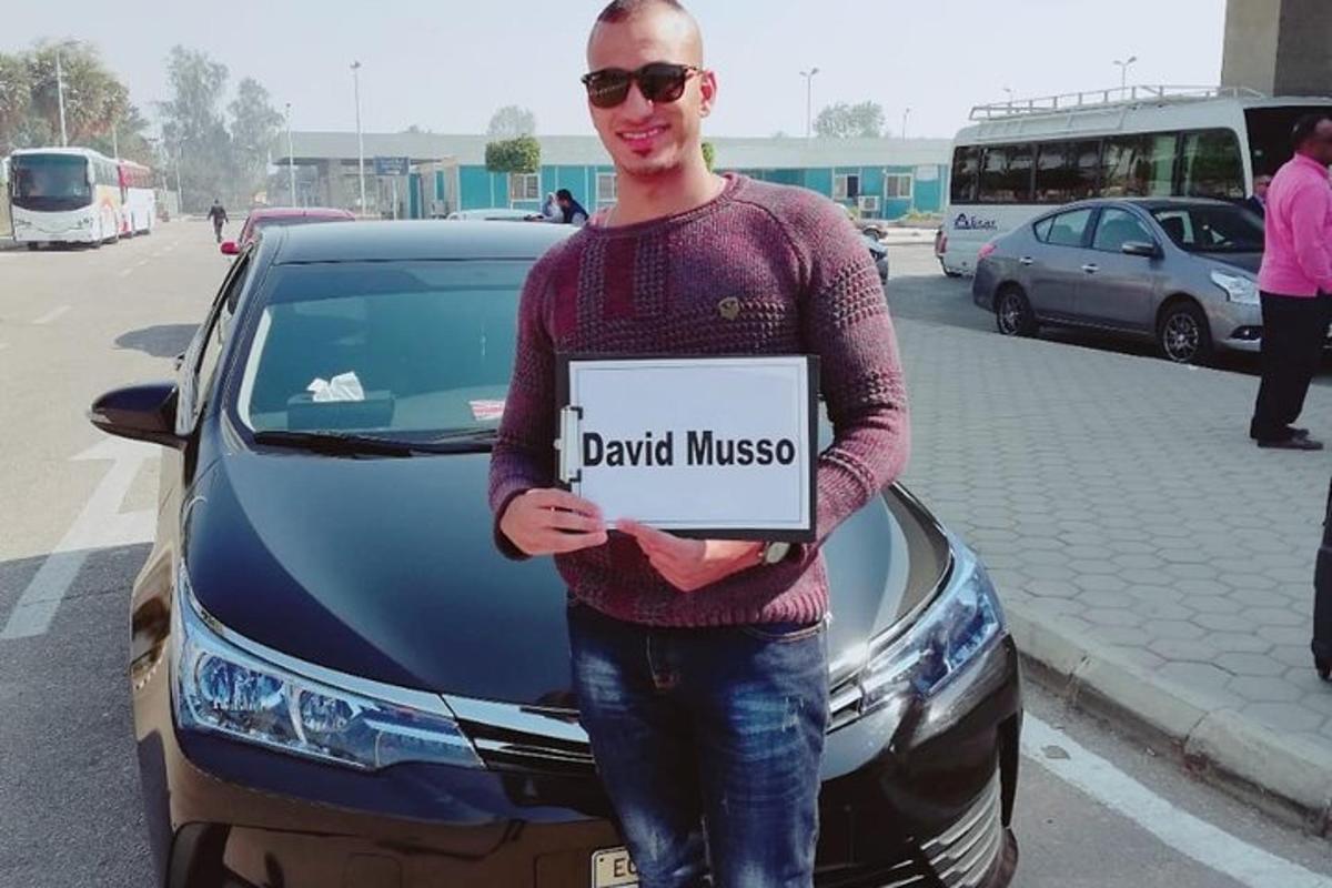 un uomo con un cartello davanti a un'auto