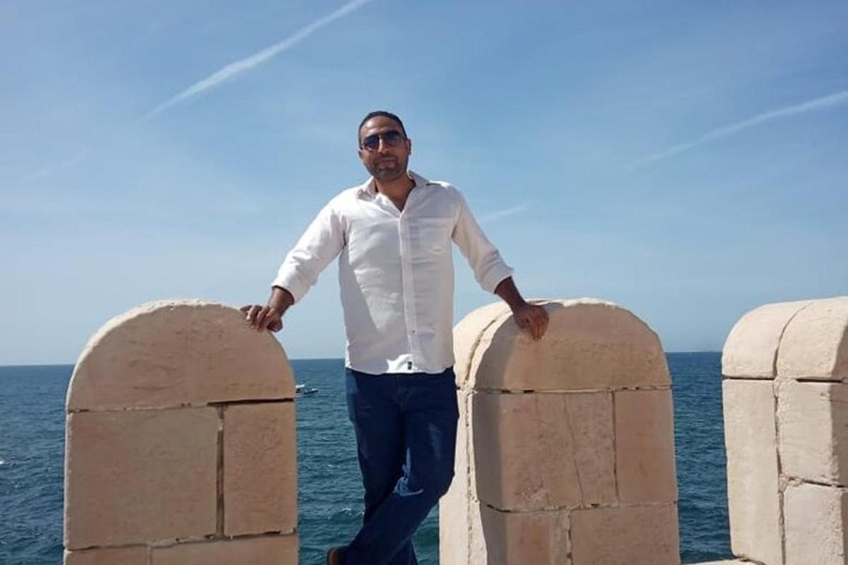 un uomo in piedi tra due barriere di pietra vicino all'oceano
