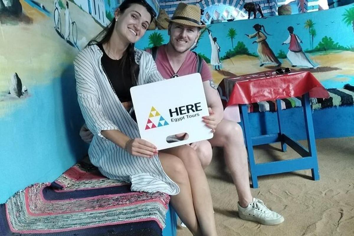 a man and woman sitting on a bench holding a sign