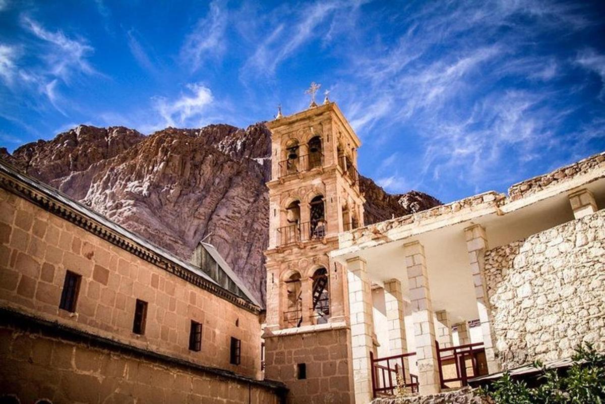un edifici amb una torre de rellotge davant d'una muntanya