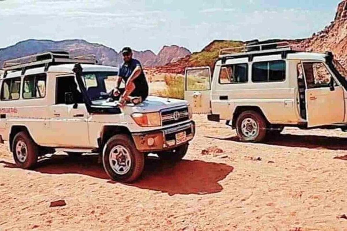 Un hombre está sentado en un vehículo en el desierto.