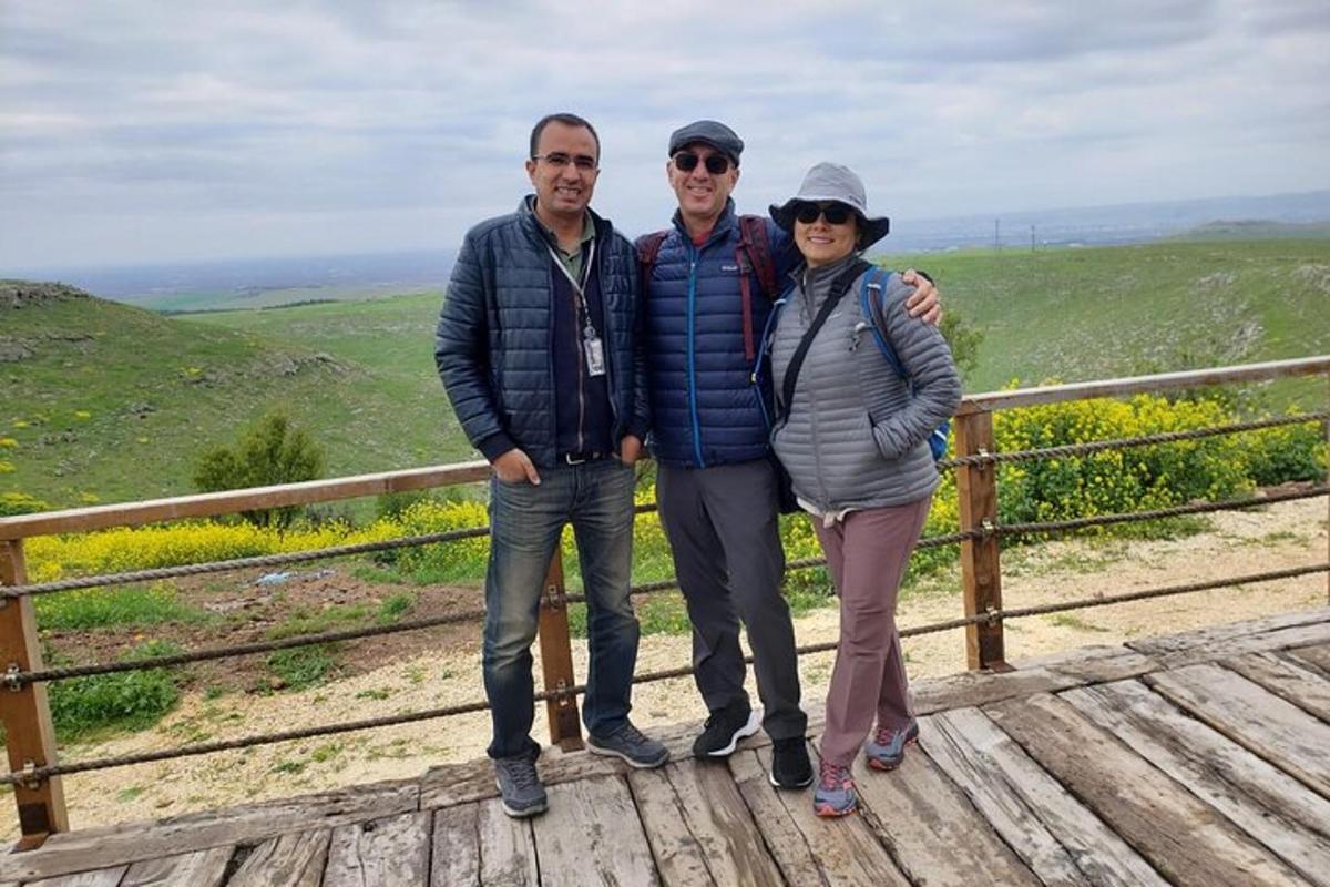 um grupo de três pessoas em pé em um calçadão de madeira