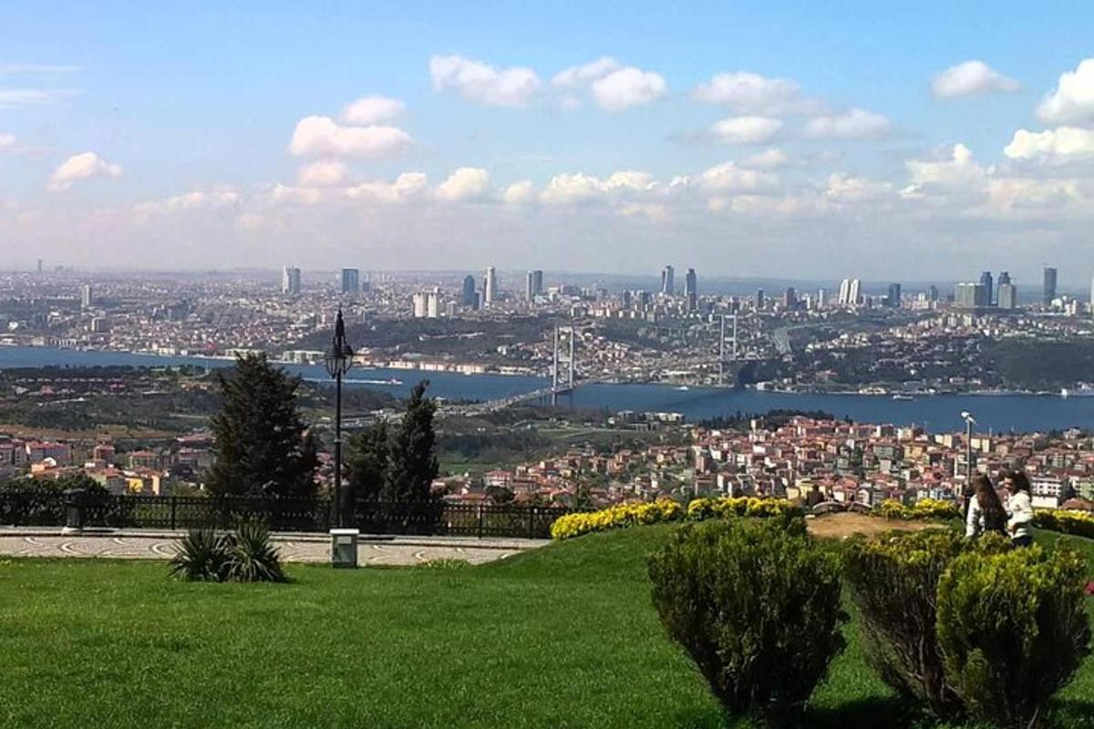 Una vista de una ciudad desde una colina con césped verde.