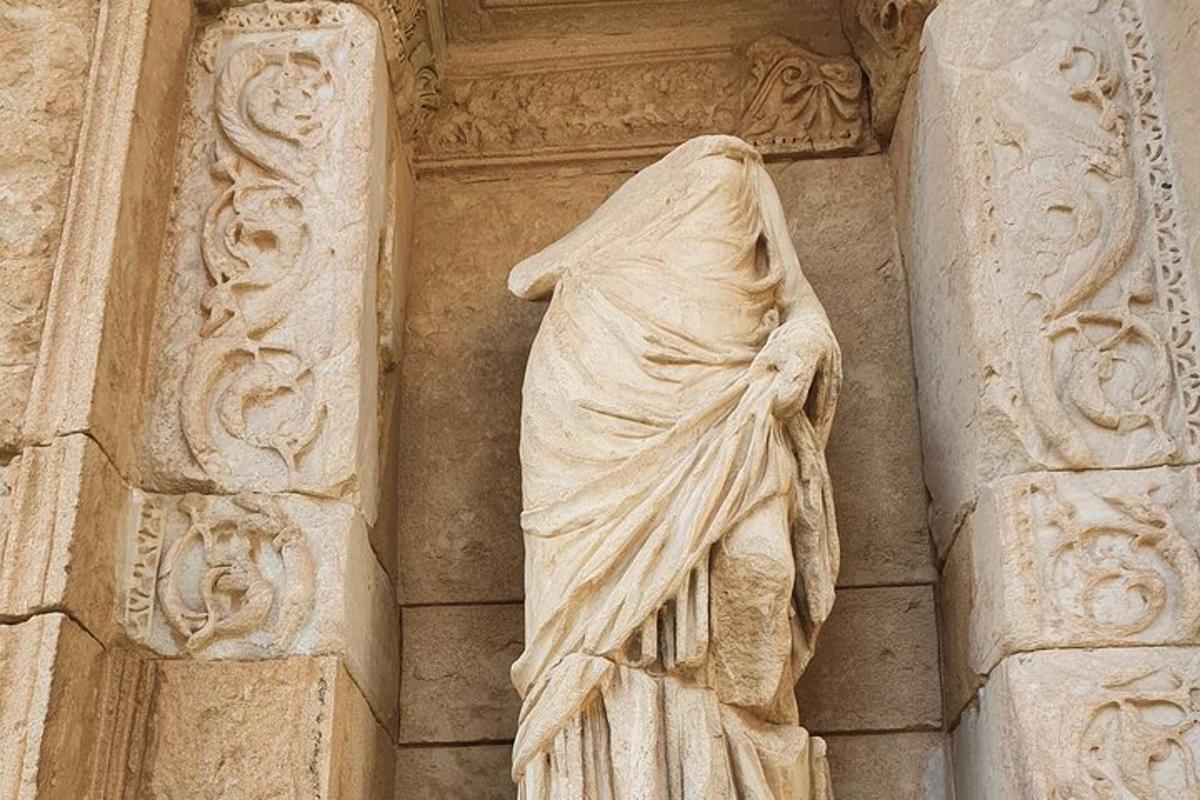 eine Statue einer Frau an der Seite eines Gebäudes